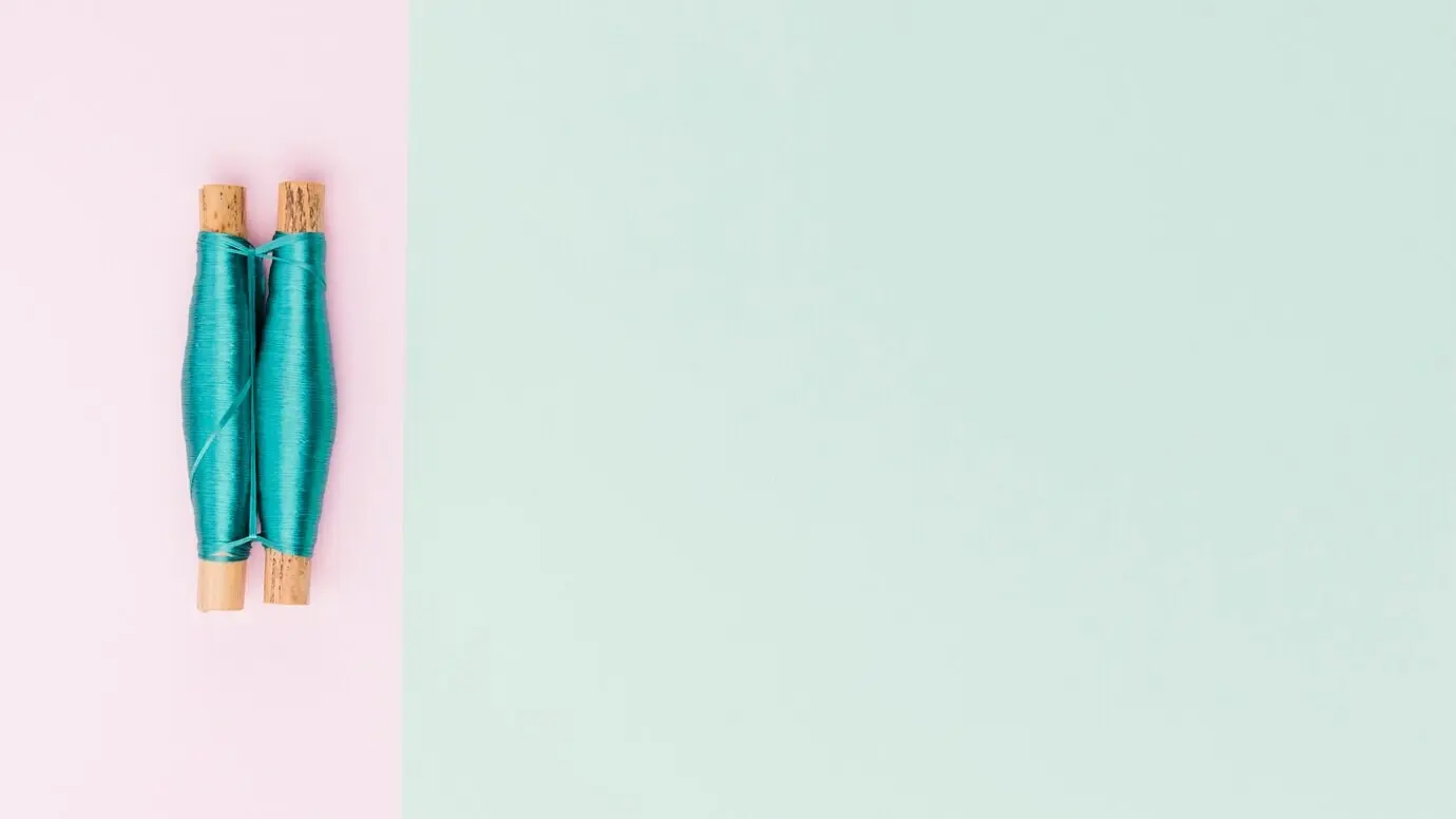 Draufsicht auf Garnspulen in Pastellfarben.